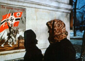 Жительницы Харькова смотрит на пропагандистский плакат нацистов. Надпись на украинском гласит «За свободу народов». Фото: waralbum.ru