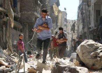 Младенцев уносят из разрушенных зданий после авиаудара в Алеппо. 2016 год. Фото: Ameer Alhalbi/Agence France-Presse/Getty Images