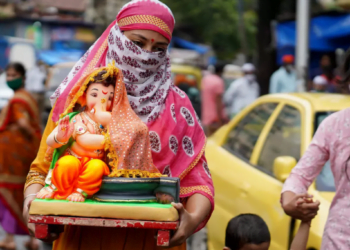 В Индии женщина несет идол индуистского бога Ганеша. 22 августа 2020 года. Фото: Reuters