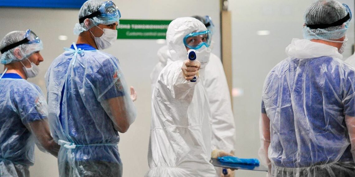 Медики, проверяющие пассажиров в аэропорту «Шереметьево». Фото: Aleksandr Avilov / AP