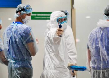 Медики, проверяющие пассажиров в аэропорту «Шереметьево». Фото: Aleksandr Avilov / AP