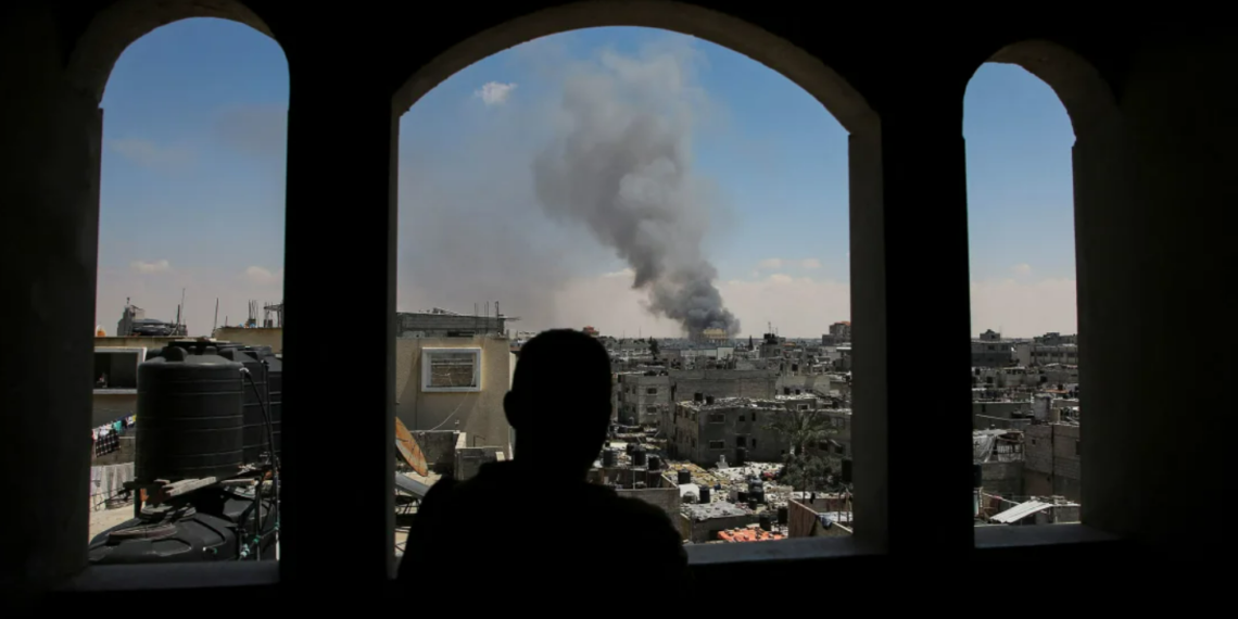 Палестинец наблюдает, как поднимается дым после израильских ударов в восточной части Рафаха. 7 мая 2024 года. Фото: Reuters