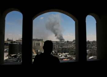 Палестинец наблюдает, как поднимается дым после израильских ударов в восточной части Рафаха. 7 мая 2024 года. Фото: Reuters