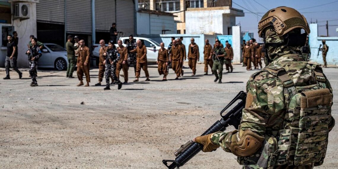 Силы безопасности сирийских курдов наблюдают за освобождением бывших задержанных, подозреваемых в принадлежности к группировке «Исламское государство»* (ИГ), в северо-восточном сирийском городе Хасеке 2 сентября 2024 года.