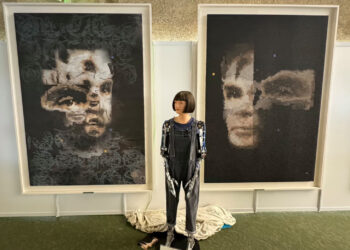 Робот Ai-Da на фоне портретов Тьюринга. Работа "AI God. Портрет Алана Тьюринга", которая была продана,  висит справа. Фото: Sotheby's/EPA