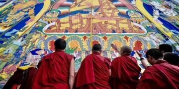 Тибетские буддийские монахи рассматривают фреску в монастыре Ташилунпо в Тибетском автономном районе, Китай. Фото: Хэ Пэнлэй / CNS / Reuters