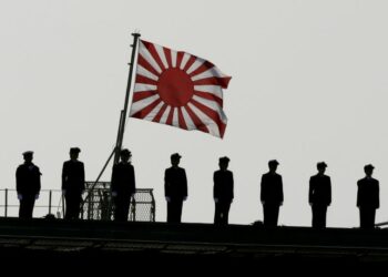 На фоне флага милитаристской Японии. Фото: The Conversation