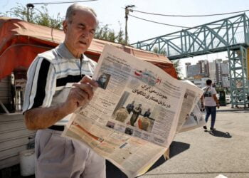 Иранец в Тегеране читает газету Etalaat с заголовком «Иран — новый член Шанхайской организации сотрудничества». 18 сентября 2021 года. Фото: AFP