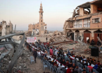 Палестинцы собрались на совместную трапезу в честь окончания поста во время Рамадана на фоне разрушений в лагере беженцев Нусейрат в секторе Газа. Фото: AFP