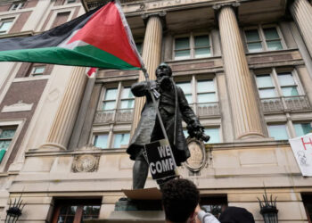 Протестующий студент Колумбийского университета несет палестинский флаг. Фото: Мэри Альтаффер/AP