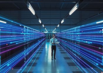 Futuristic Concept: Data Center Chief Technology Officer Using Laptop, Standing In Warehouse, Information Digitalization Lines Streaming Through Servers. SAAS, Cloud Storage, Online Service