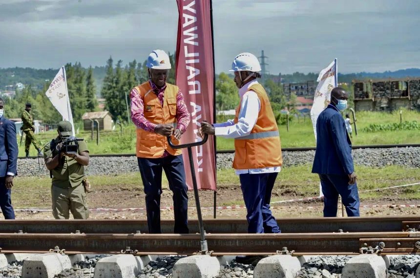 Президент Кении Уильям Руто (слева) и президент Уганды Йовери Мусевени (справа) присутствуют на церемонии начала строительства линии стандартной колеи (SGR) Кисуму–Малаба в Кисуму, Кения, 21 марта 2026 года. Линия соединит не имеющую выхода к морю Уганду с Кенией, заменит старую колониальную инфраструктуру и станет частью сети, которая заканчивается в портовом городе Момбаса. Фото: AFP / Getty